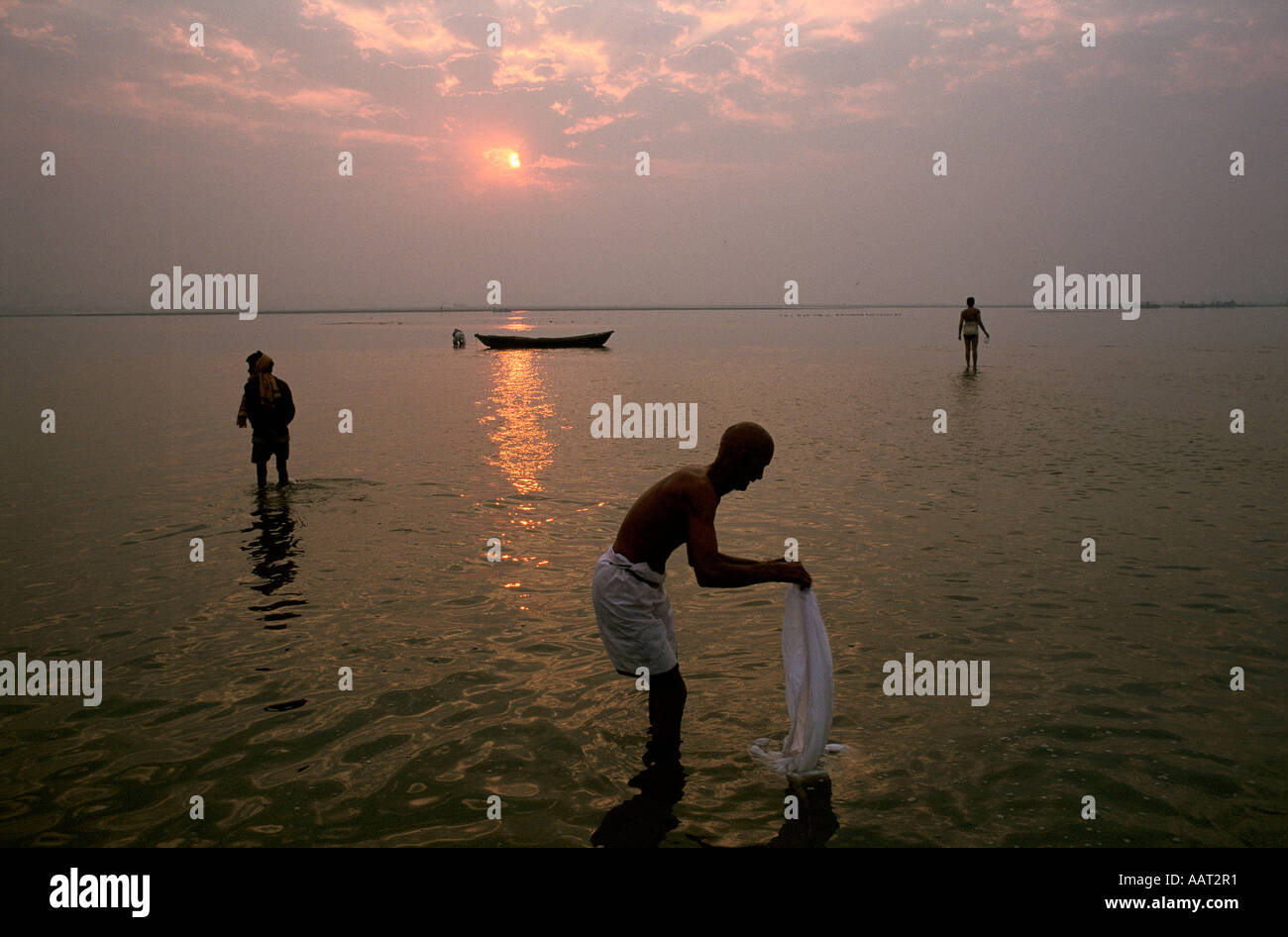 KUMBH MELA INDIA 2001 AS THE SUN SETS OVER ALLAHABAD THE MILLIONS OF PILGRIMS CONTINUE TO WASH AND PRAY 2001 Stock Photo