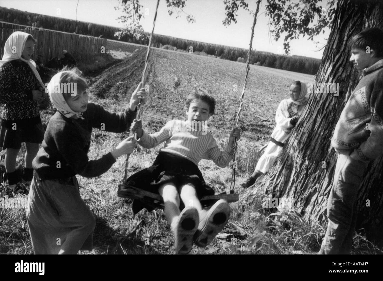 Children of the believers on a 4 day pilgrimage playing on a swing set up by their parents a break from walking Stock Photo