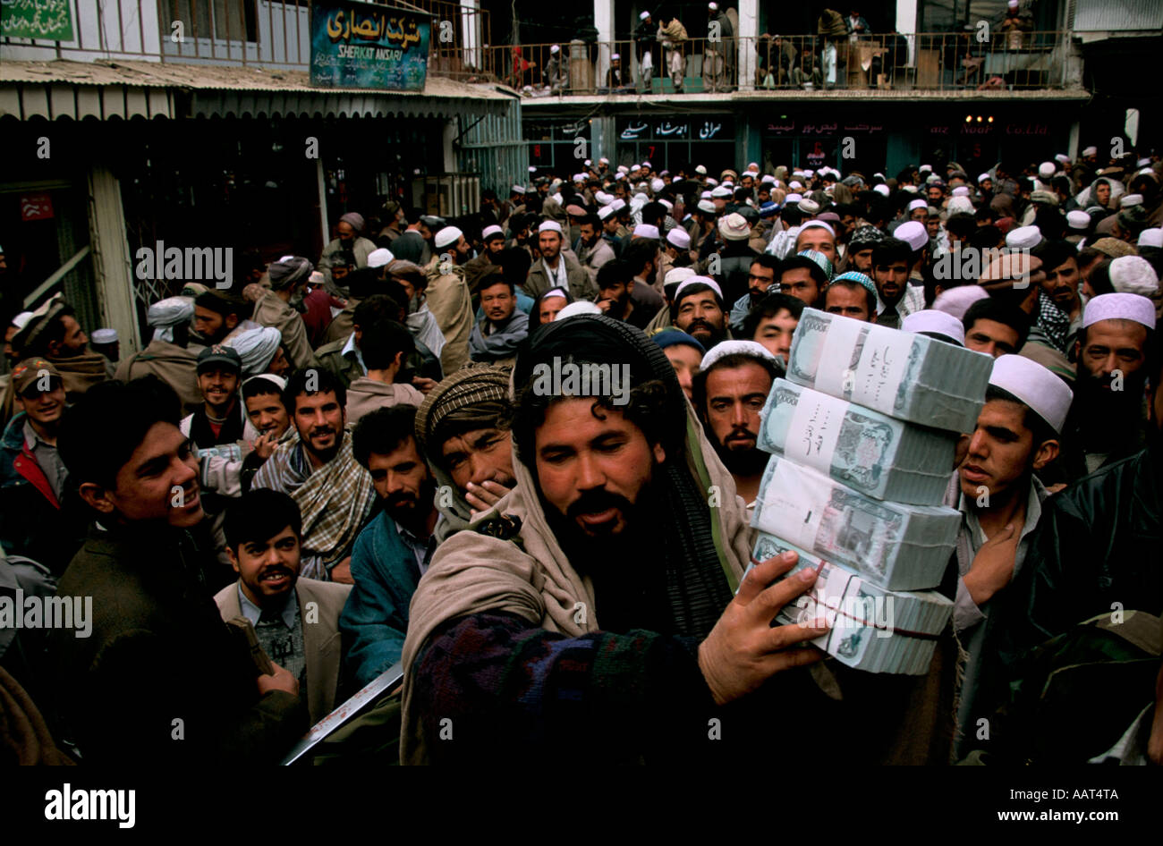 An Afghani businessman takes a huge wad of Afghani notes through the Afghan stock exchange. Stock Photo
