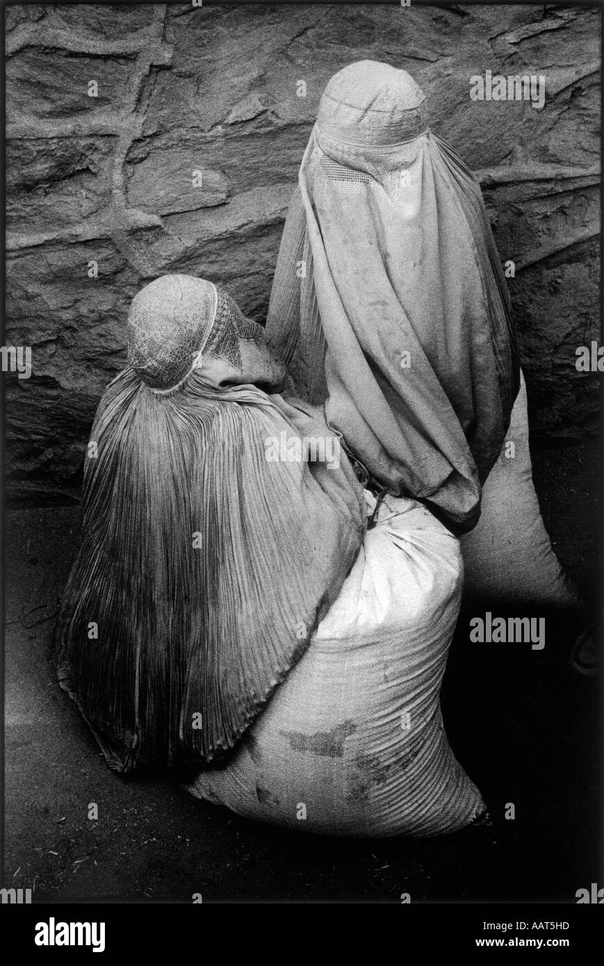 REBIRTH OF A NATION KABUL WOMEN WAITING FOR CARTS TO TAKE HOME THE SACKS OF WHEAT DONATED THROUGH W F PROGRAMME 2001 Stock Photo