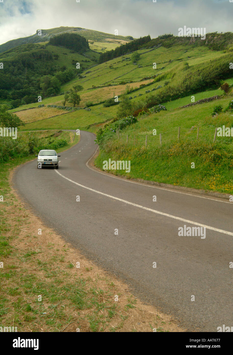 A road near the town of Lages through hilly patchwork farm fields on the island of Flores in the Azores Stock Photo