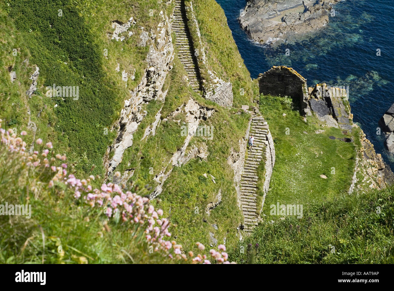 dh North coast 500 WHALIGOE CAITHNESS Man walking down steep stone steps to cove fishing harbour carved out of seacliff scotland tourist Stock Photo