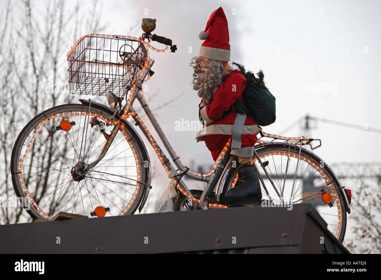 Inflatable Santa Claus with bicycle on rooftop. Outdoor Christmas