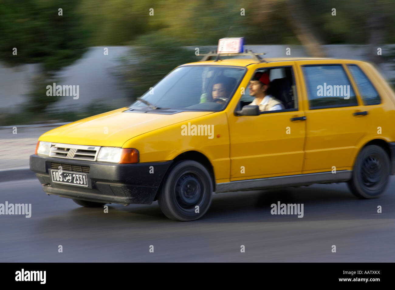 old yellow fiat taxi with passenger moving at speed in hammamet tunisia Stock Photo Alamy