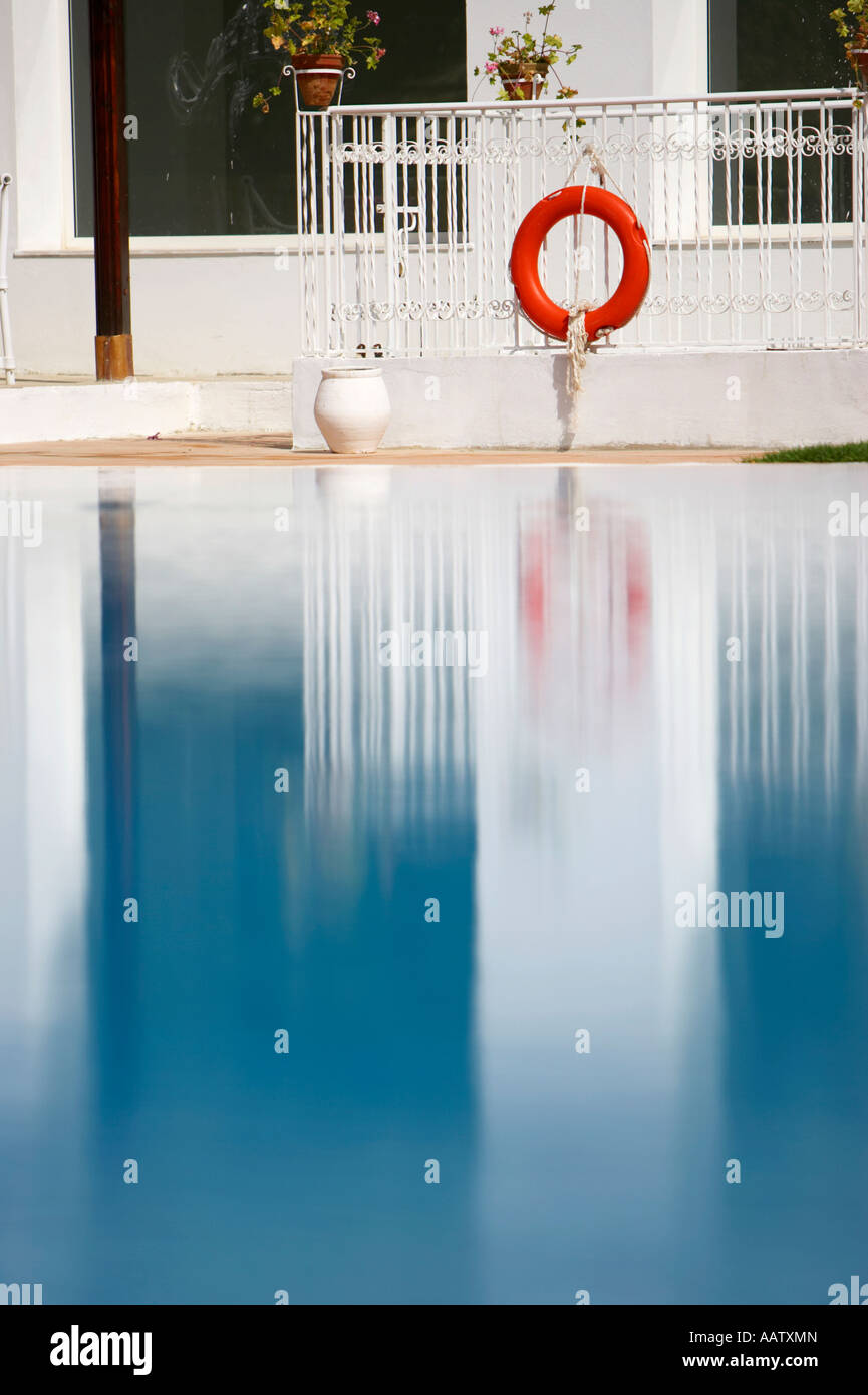 red lifebelt and reflection in still blue swimming pool in resort hotel hammamet tunisia Stock Photo