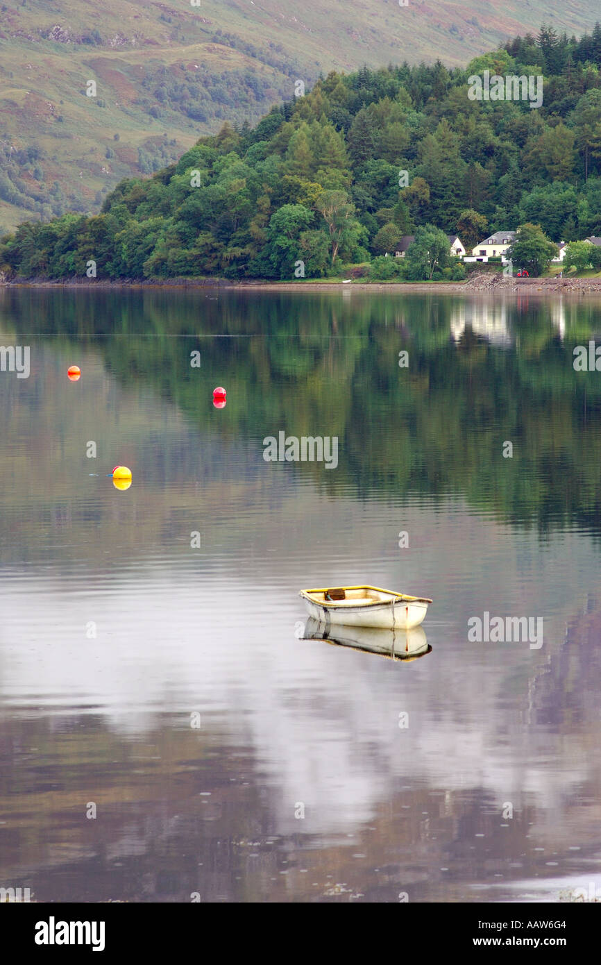 Small dinghy boat moored on Loch Leven near Ballachulish Glencoe with three colourful buoys and forested hillside Stock Photo