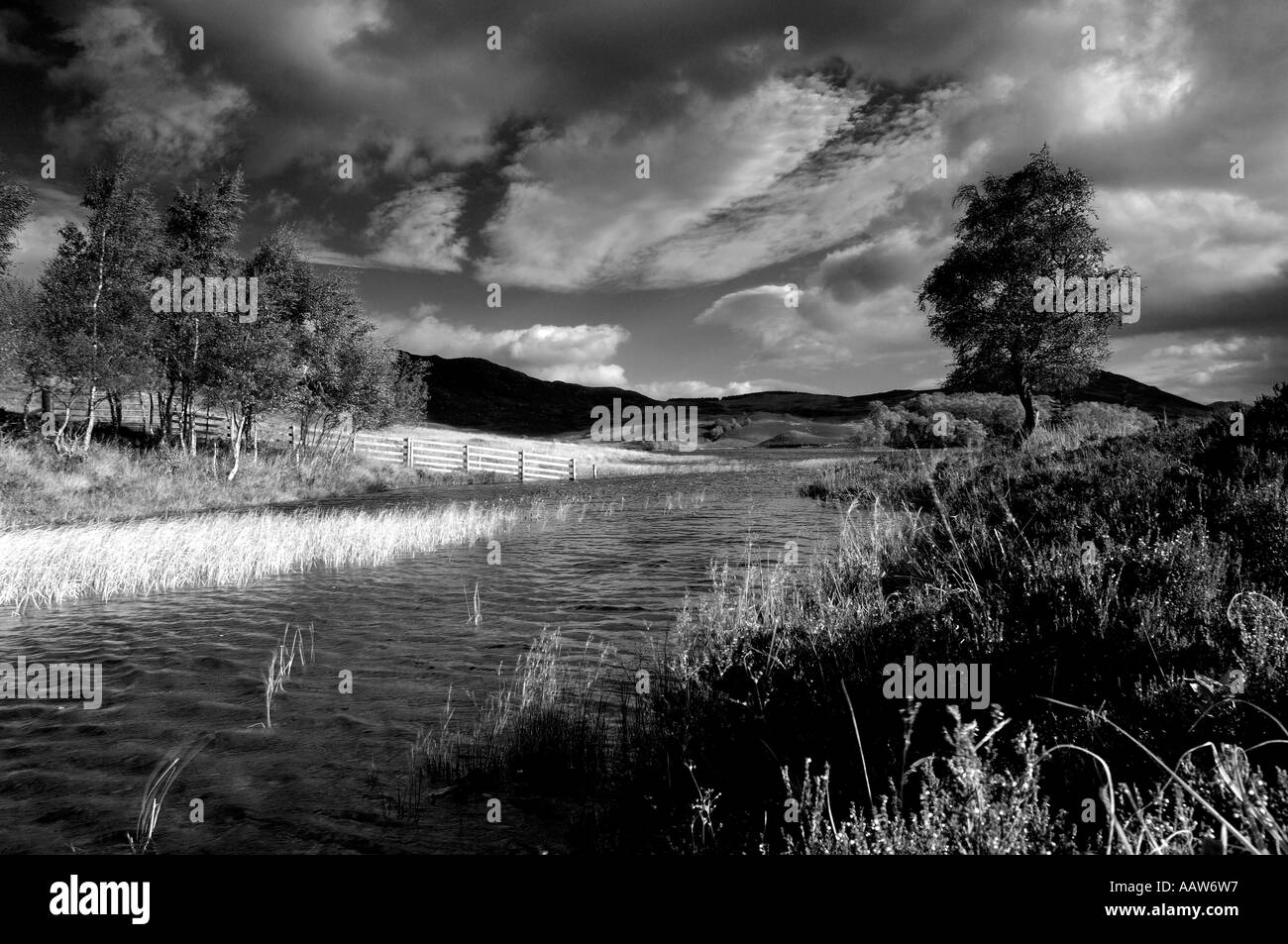 Very atmospheric high contrast monochrome image of Loch Tarff in the Scottish highlands with fantastic light from evening sun Stock Photo