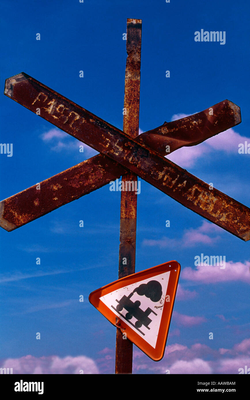 rusty railway line pedestrian crossing sign with crooked train warning ...