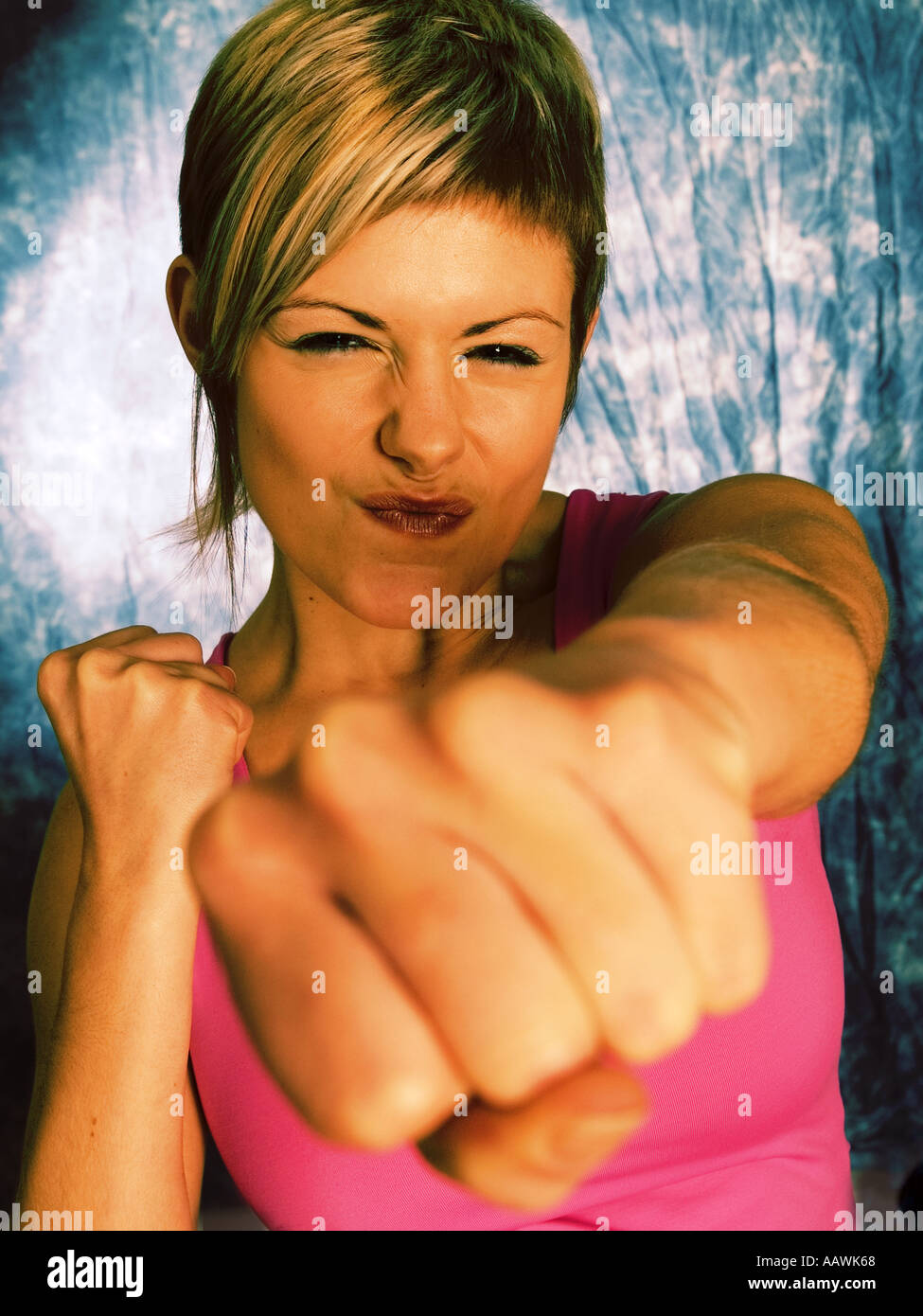 Girl punching at camera with cross processed effect Stock Photo