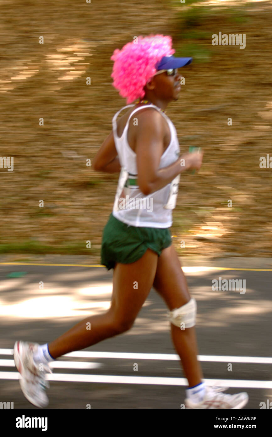 A man in a pink wig running the Two Oceans Marathon in Cape Town, South Africa. Stock Photo