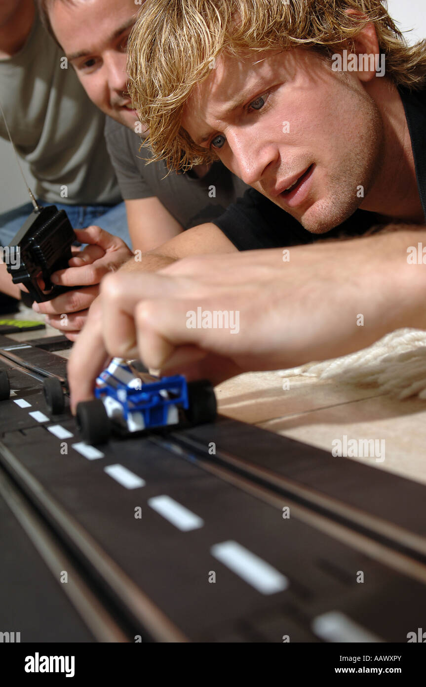 3 young men with Carrera model railway Stock Photo