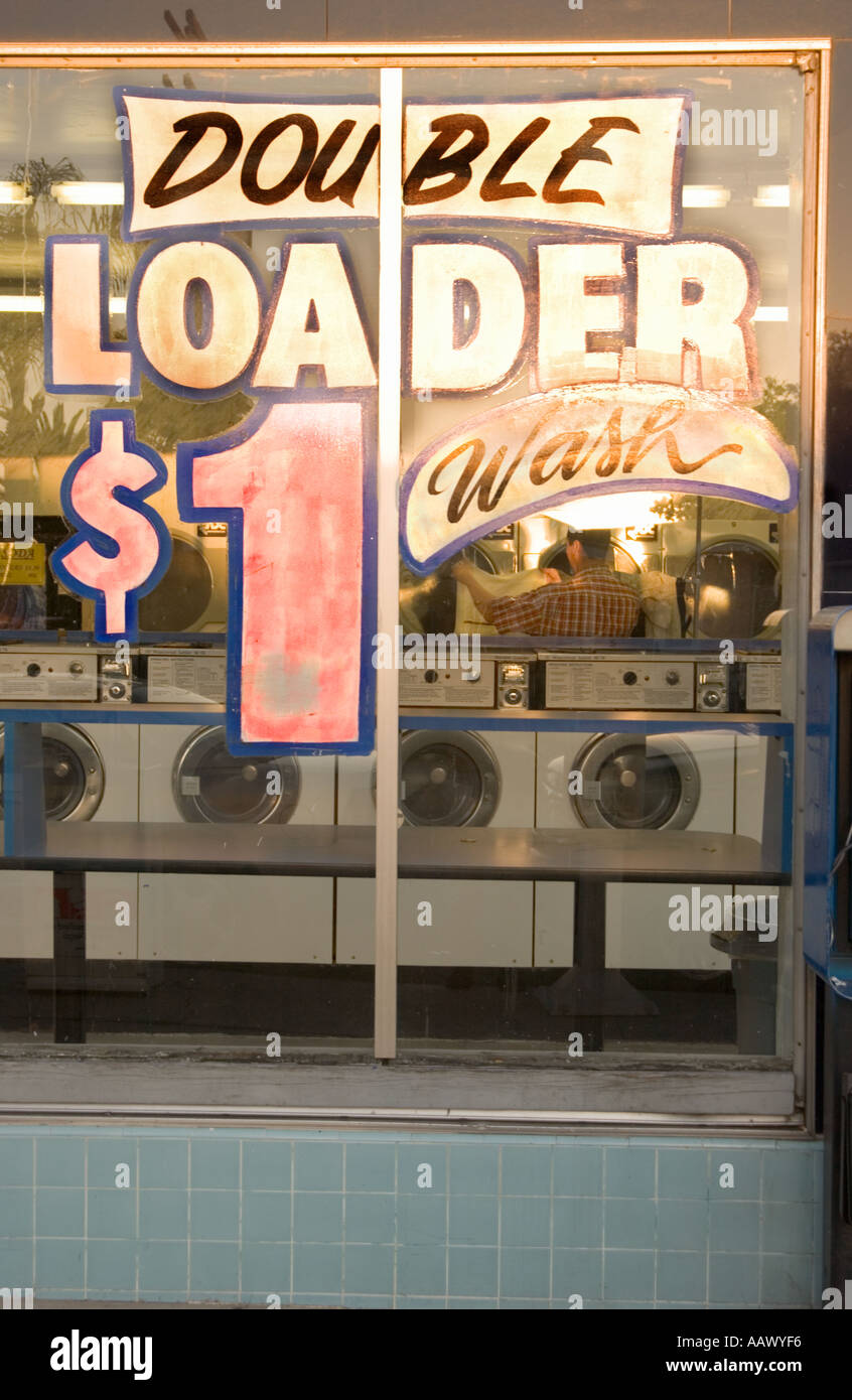 A color vertical image of the front window of a laundromat with a colorful sign Stock Photo Alamy