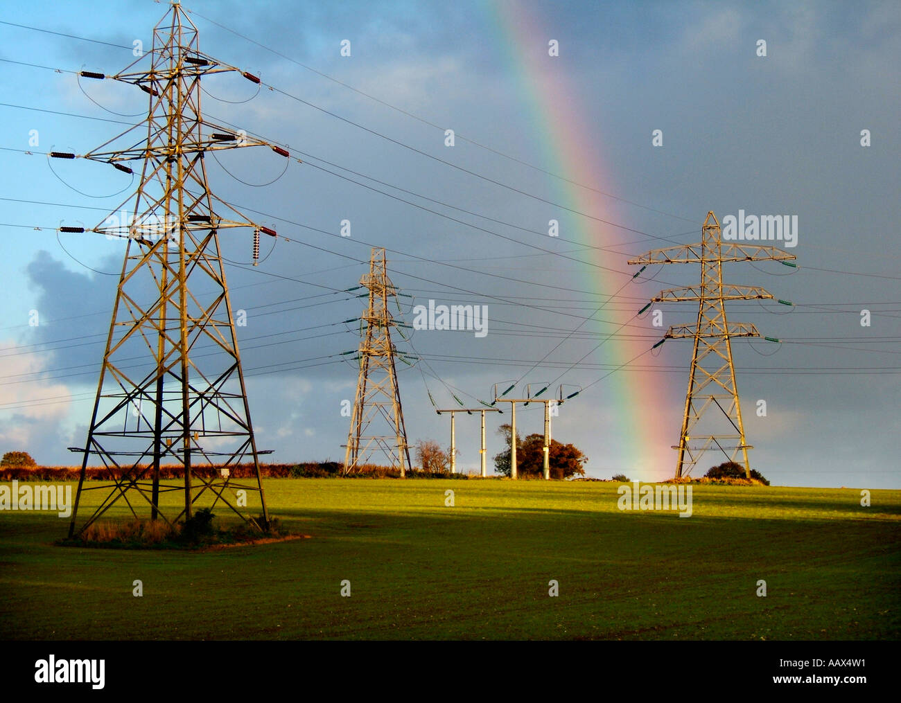 rainbow over electricity pylons Stock Photo