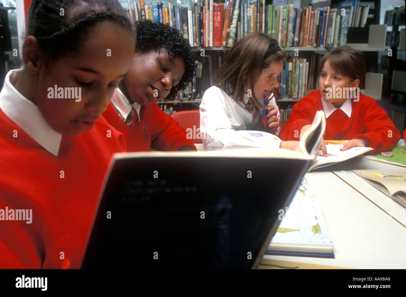 A group of students studying together working on their homework in the school library. Stock Photo
