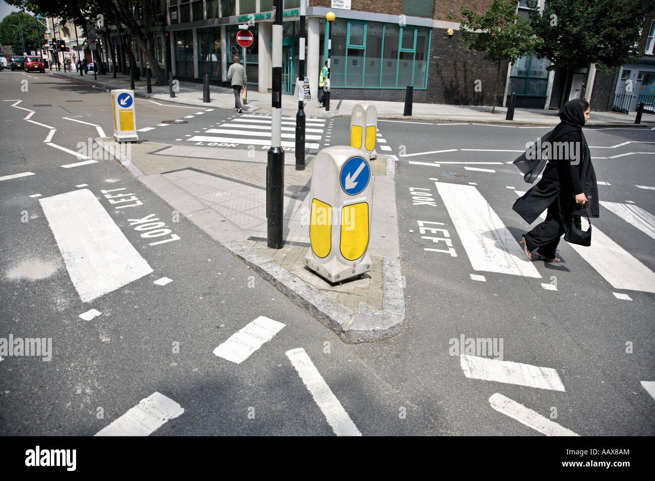 a muslim woman walks across a zebra crossing in east london Stock Photo