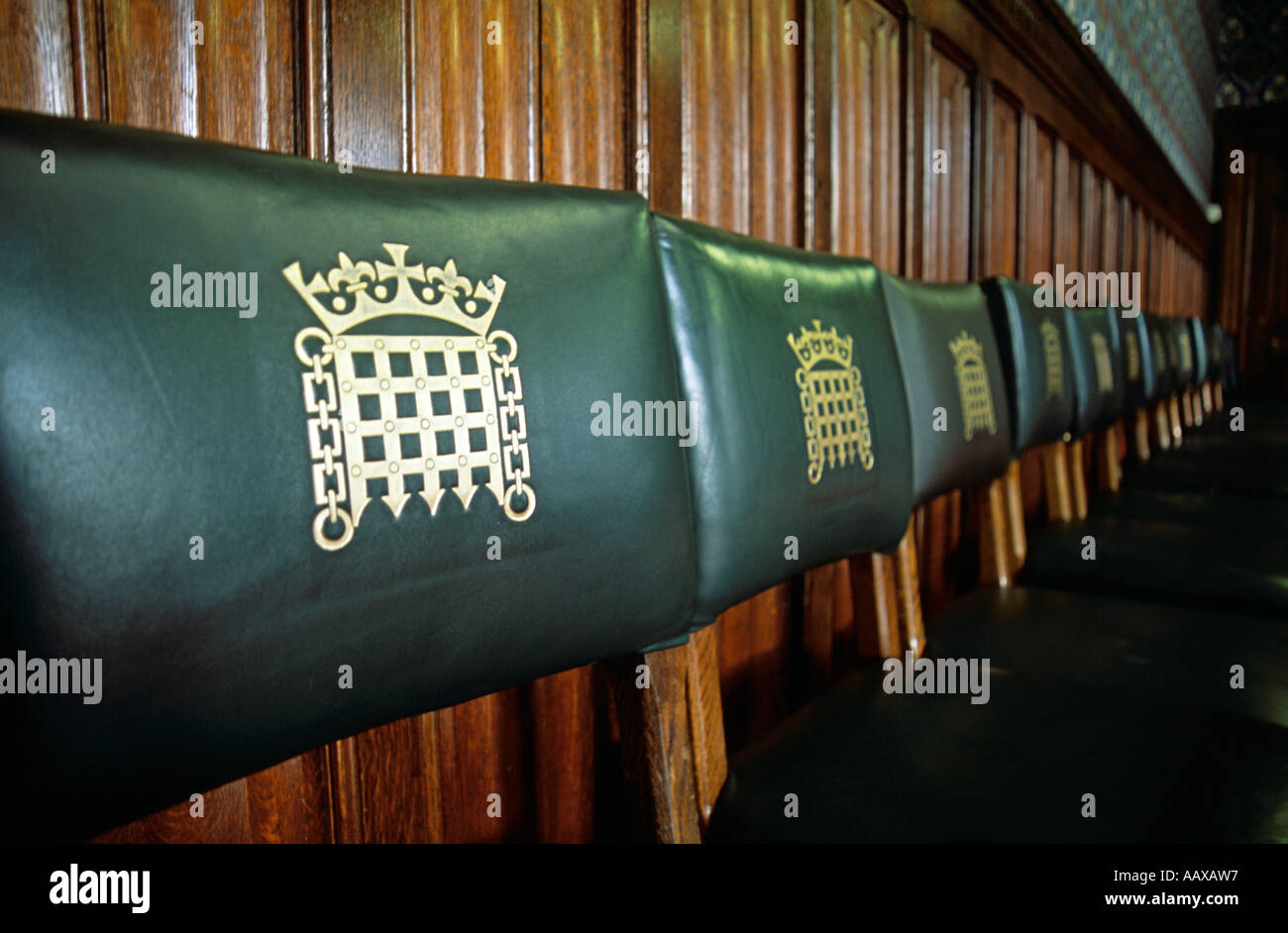 Row of chairs in a reception room in the houses of parliament UK London with logo Parliamentary seat.Palace of westminister. Stock Photo