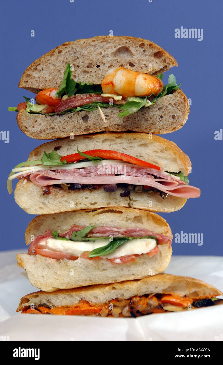 Pile of gourmet sandwiches piled high cut in half meats cheeses and vegetables Stock Photo