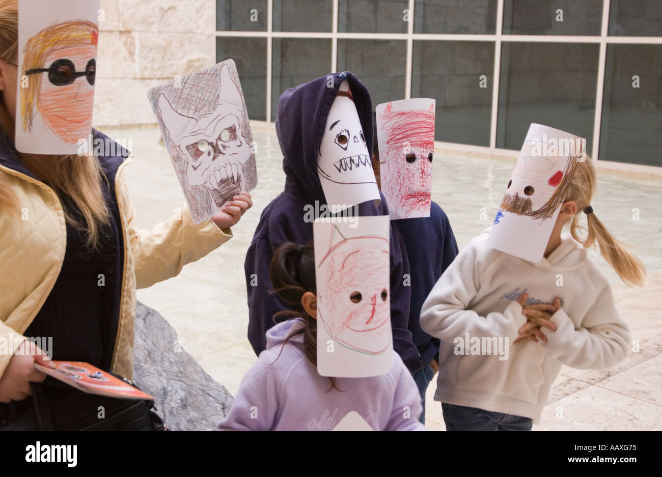 Several children wearing hand drawn masks at the Getty Museum in Los Angeles California Stock Photo