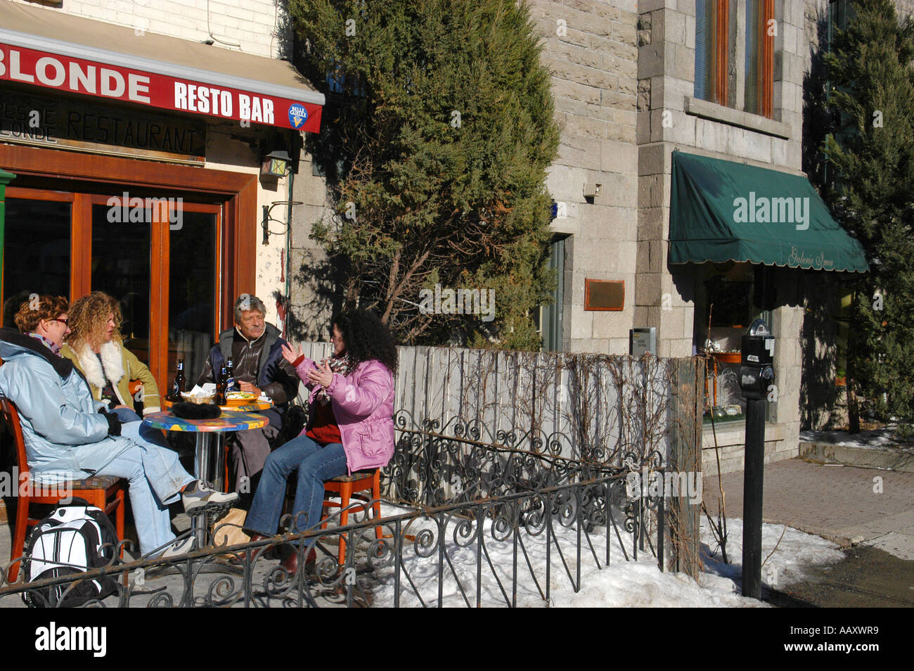 People enjoying a beer on a terrace on St Denis street during the month of march Montreal Quebec Canada Stock Photo