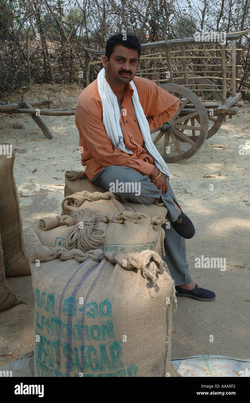 Indian farmer sitting on packed wheat gunny bags in village Mahangwa District Narsinghpur Madhya Pradesh India - ANA 99972 Stock Photo