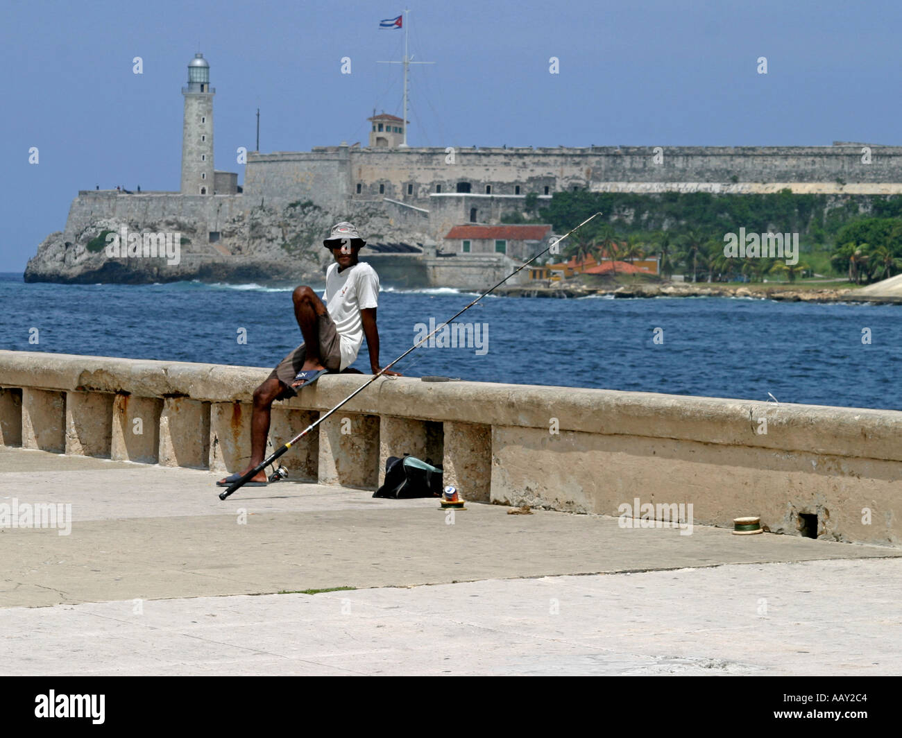 An angler in the Cuban capital Havana with Fort Morro in the background Stock Photo