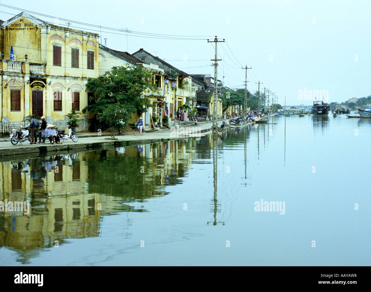 Old buildings along Bach Dang St reflected in high flood waters of the Thu Bon river, overcast afternoon, Hoi An, Viet Nam Stock Photo