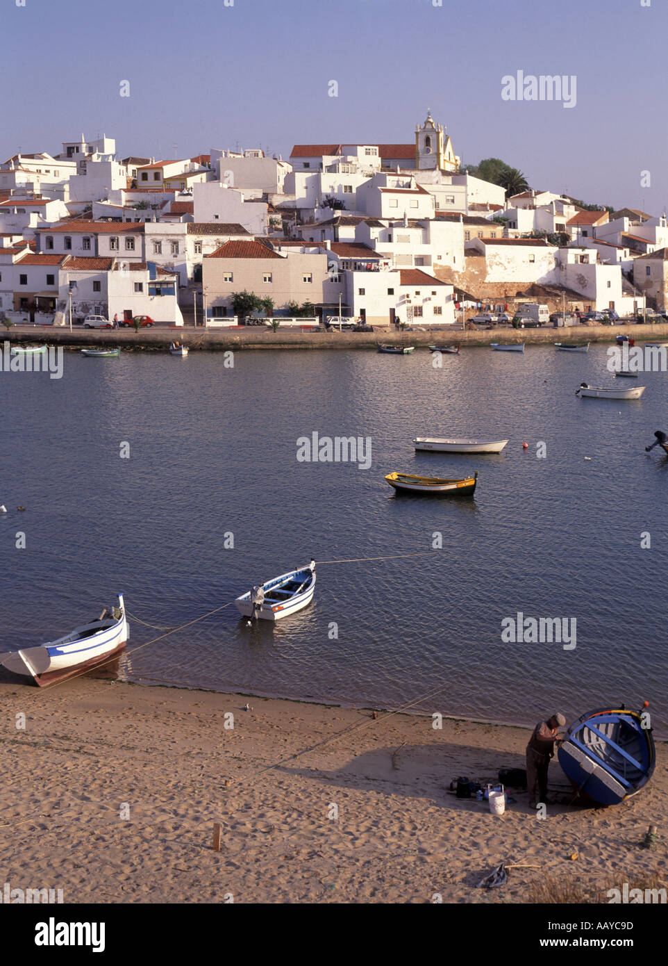 Algarve Ferragudo village beyond beach and moored fishing boat in harbour Stock Photo