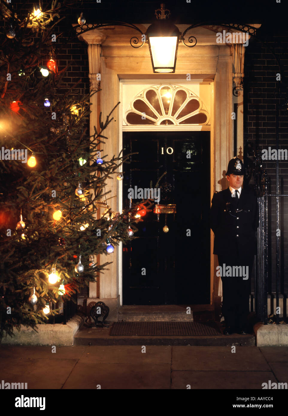 Number 10 Downing street front door and duty police constable beside Christmas tree Stock Photo
