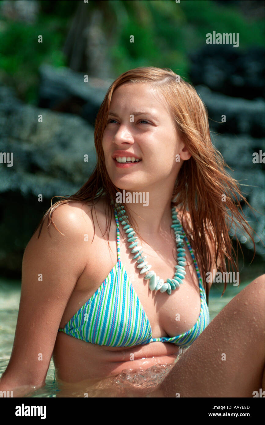 portrait of teenage girl in bikini sitting in the water Stock