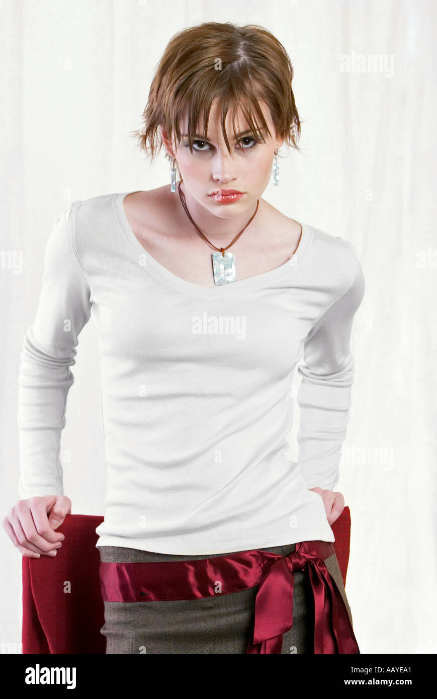 Glamorous young woman leaning against a chair Stock Photo Alamy