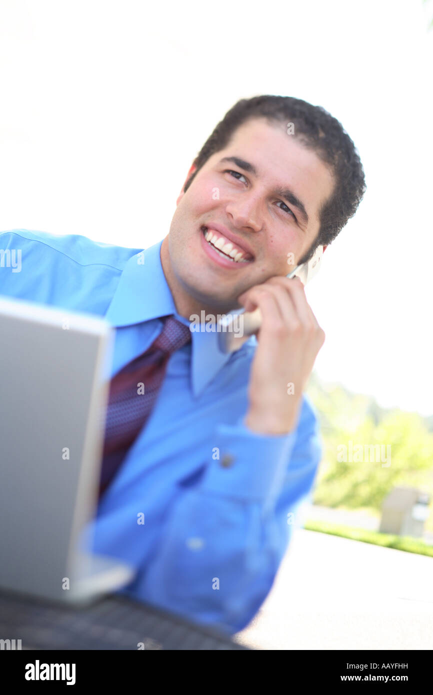 Young businessman using laptop and cell phone Stock Photo