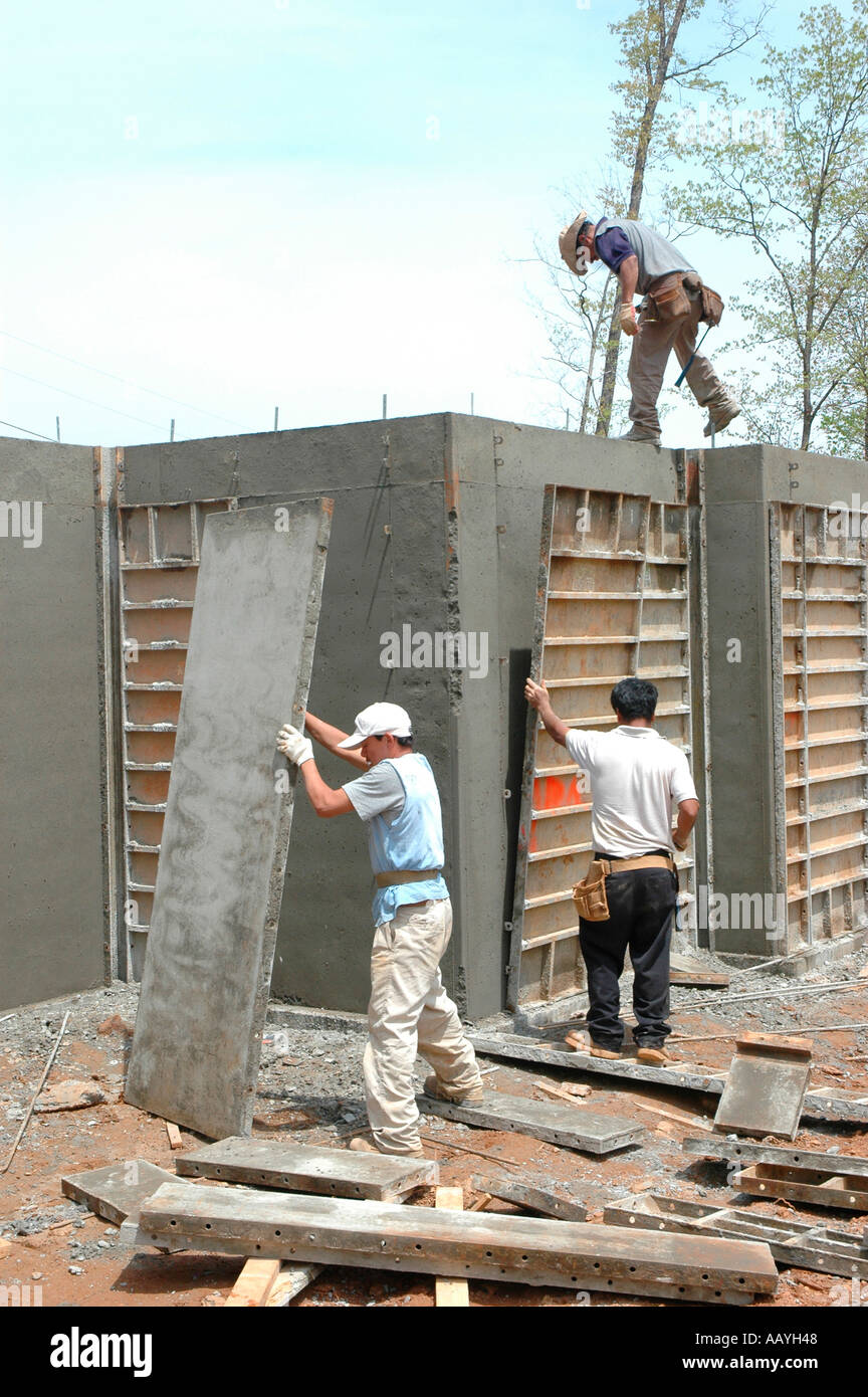 Putting in Cement footings for walls of new house by Latin labor laborers with delivery truck