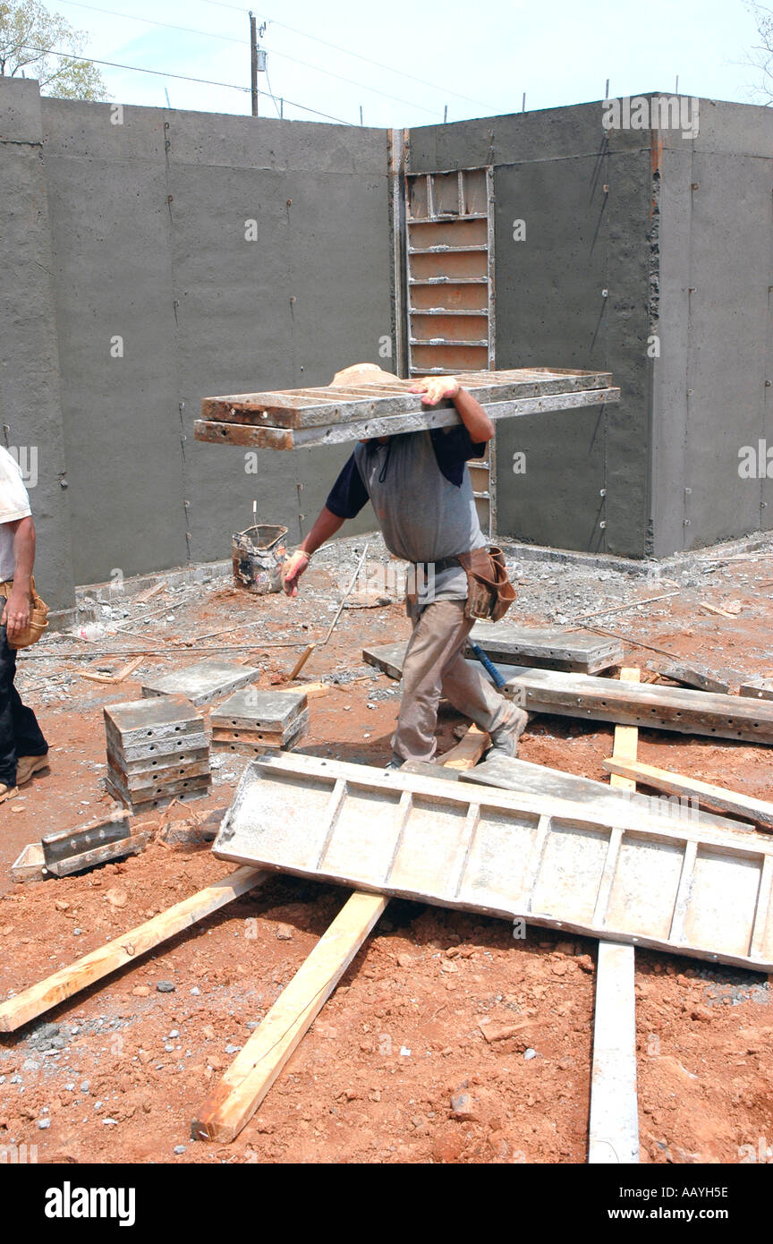 Putting in Cement footings for walls of new house by Latin labor laborers with delivery truck