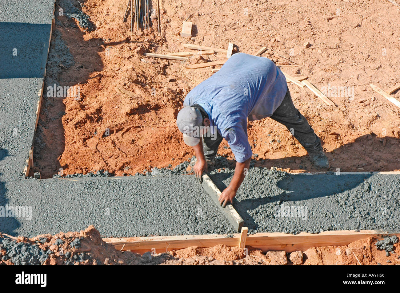 Putting in Cement footings for walls of new house by Latin labor laborers with delivery truck