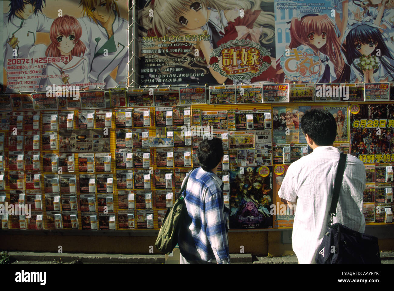 Otaku men looking at posters and vending boxes for toys in a street in Akihabara in Tokyo, Japan Stock Photo