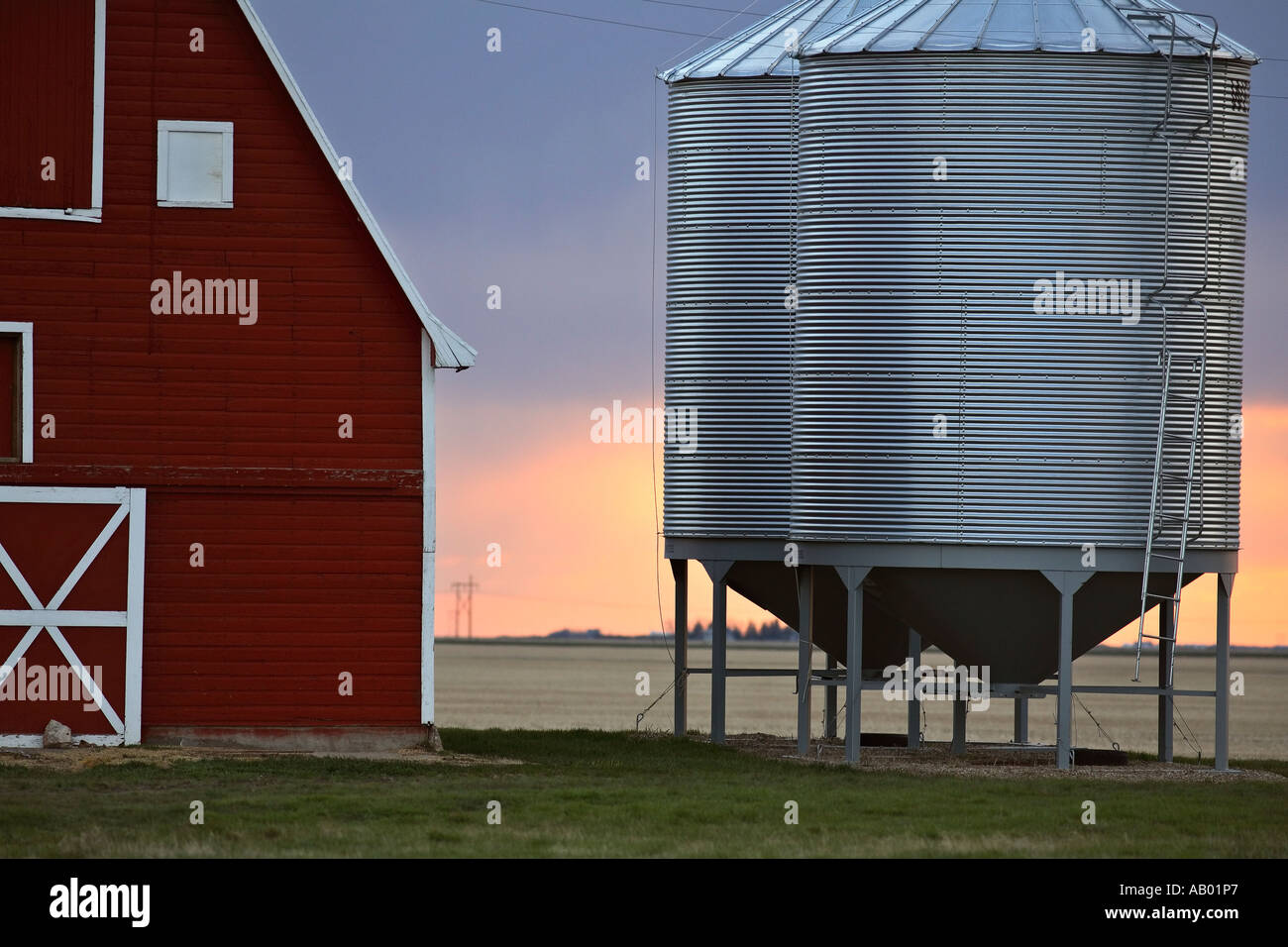 Red barn and metal grain bins in scenic Saskatchewan Canada Stock Photo