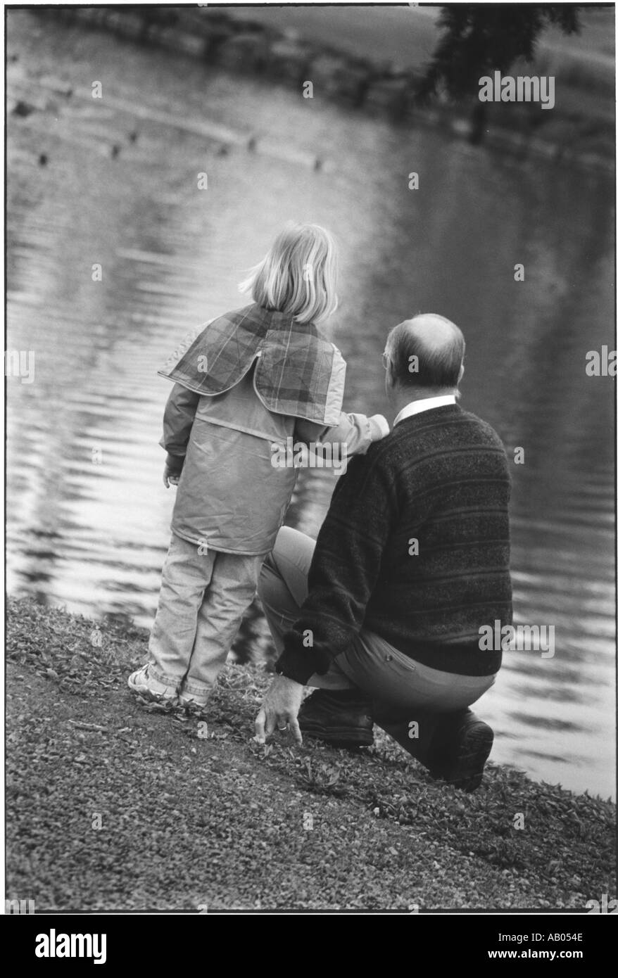 Grandfather and granddaughter at lake Stock Photo