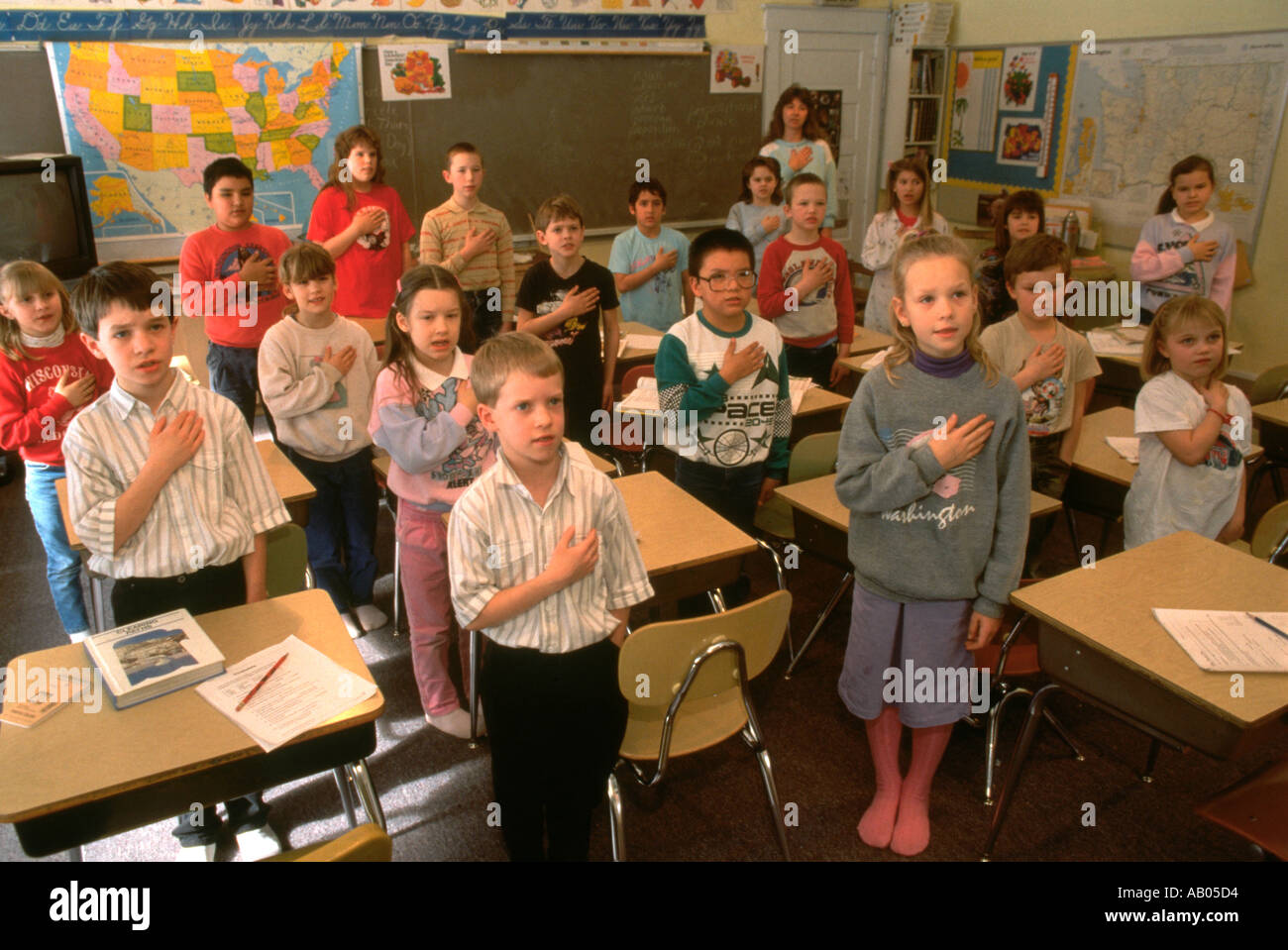 Children in classroom saying the Pledge of Allegiance Stock Photo