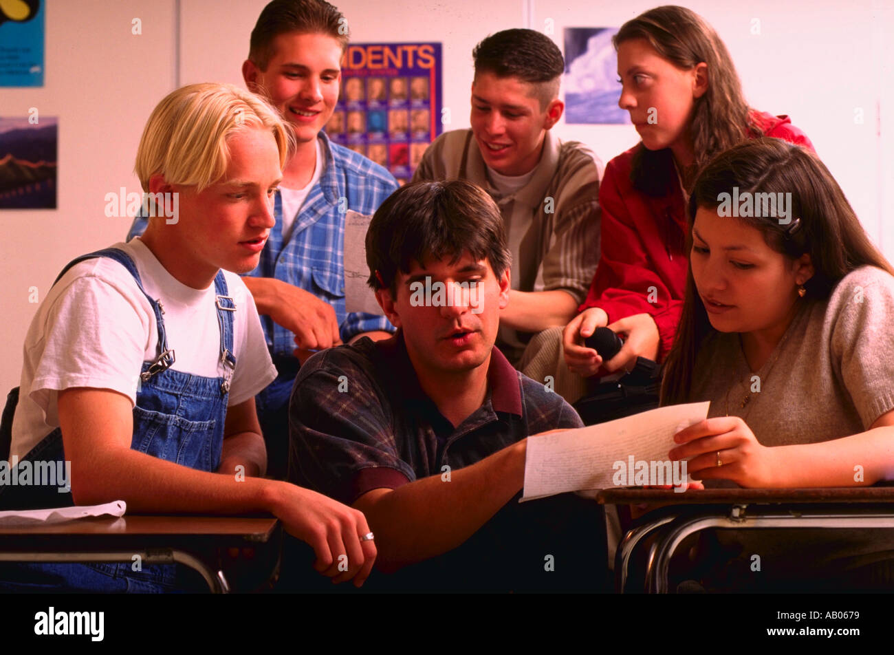 Multi ethnic group of high school students talking together in classroom Stock Photo