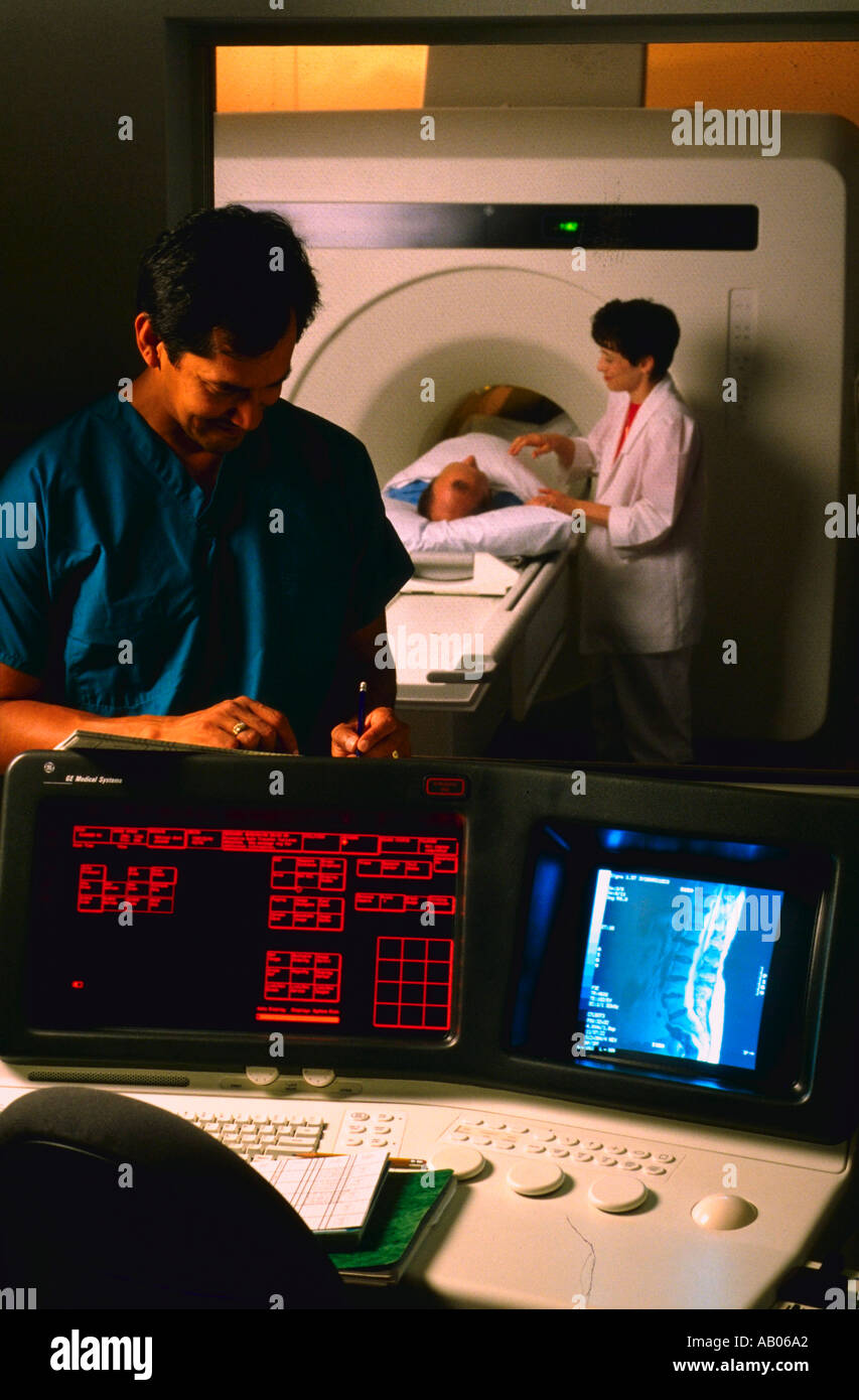 CT scan technician at operating controls with nurse explaining
