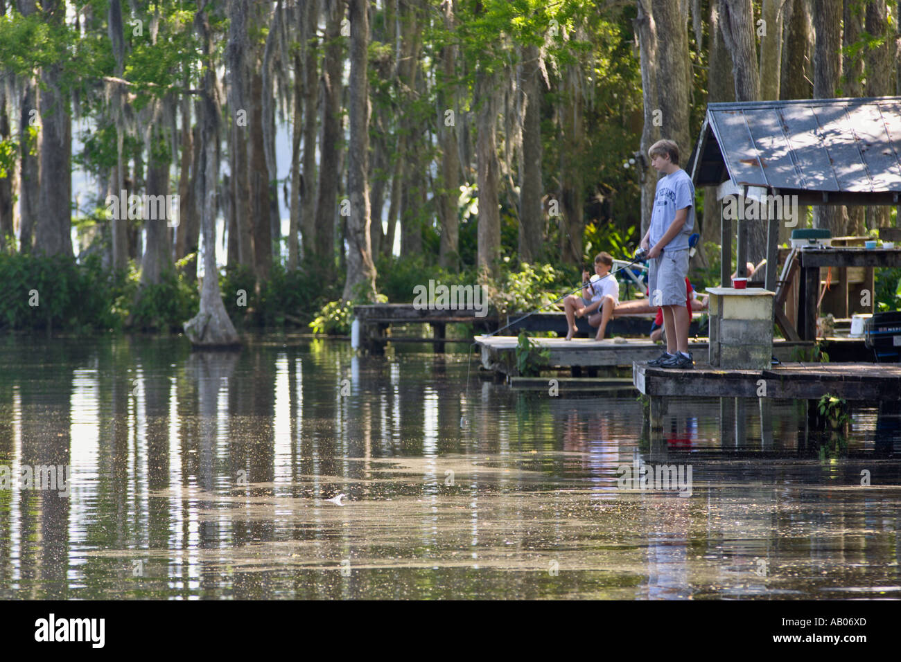Lake Rousseau Rv Resort Young boy fishes off wooden dock in marina at Lake Rousseau RV Resort ...