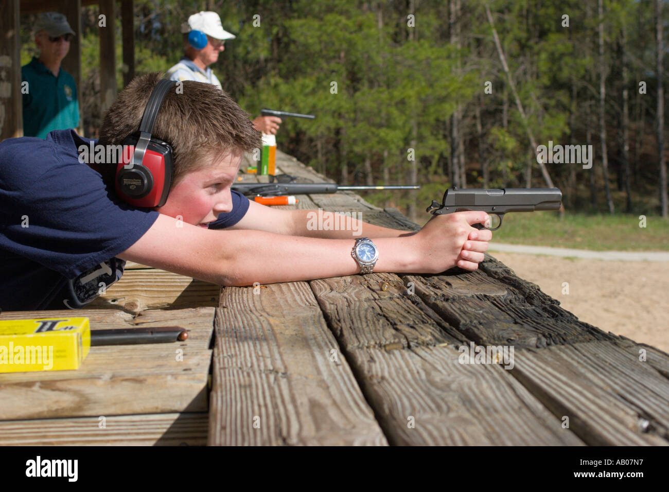 Teenager aims 45 caliber handgun during target practice at firing range