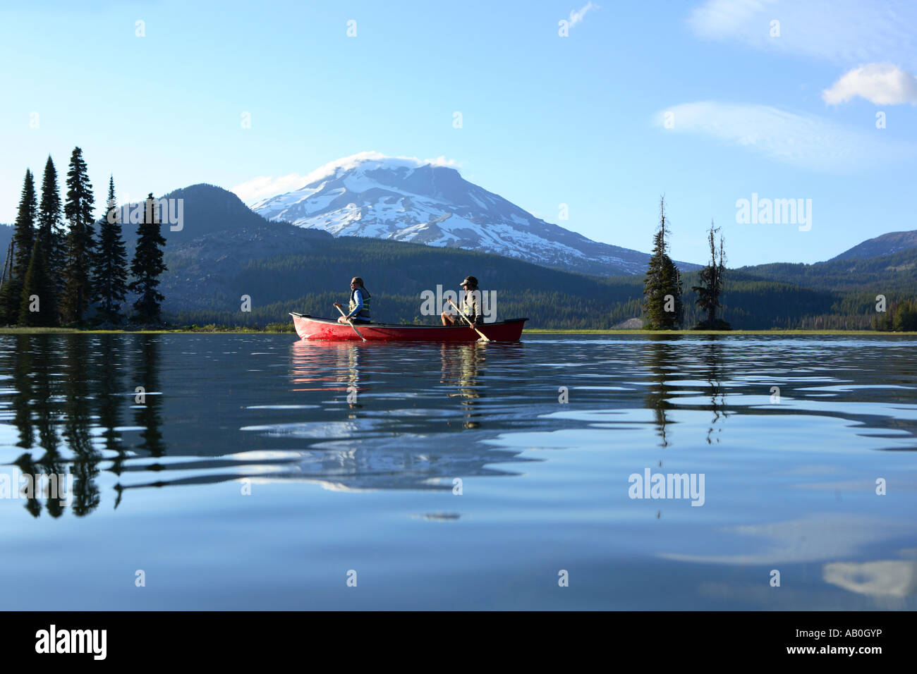 Couple paddling canoe on lake Stock Photo