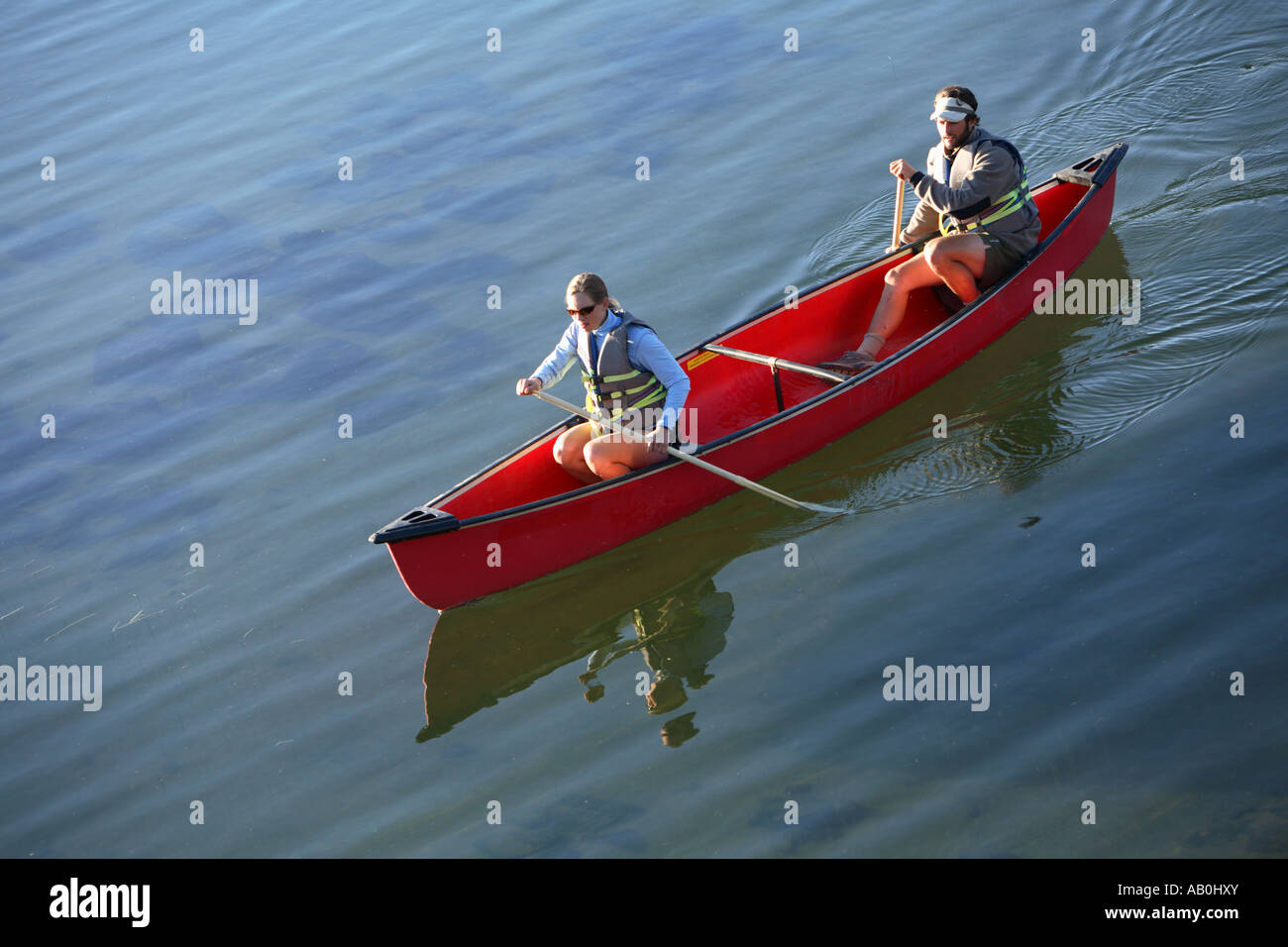 Couple paddle canoe on lake Stock Photo Alamy
