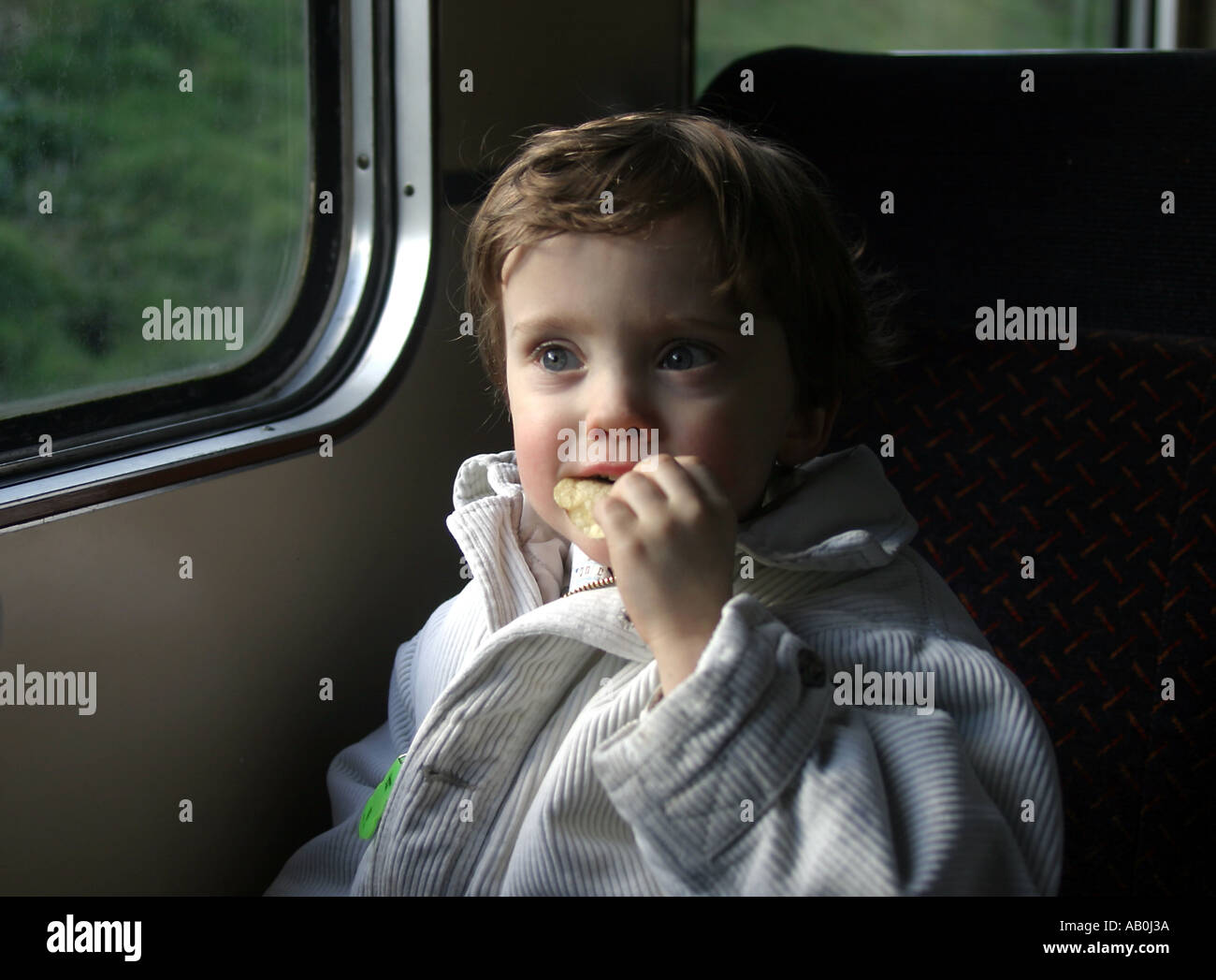 boy enjoys a crisp on the train The Great Central Railway in Loughborough Stock Photo