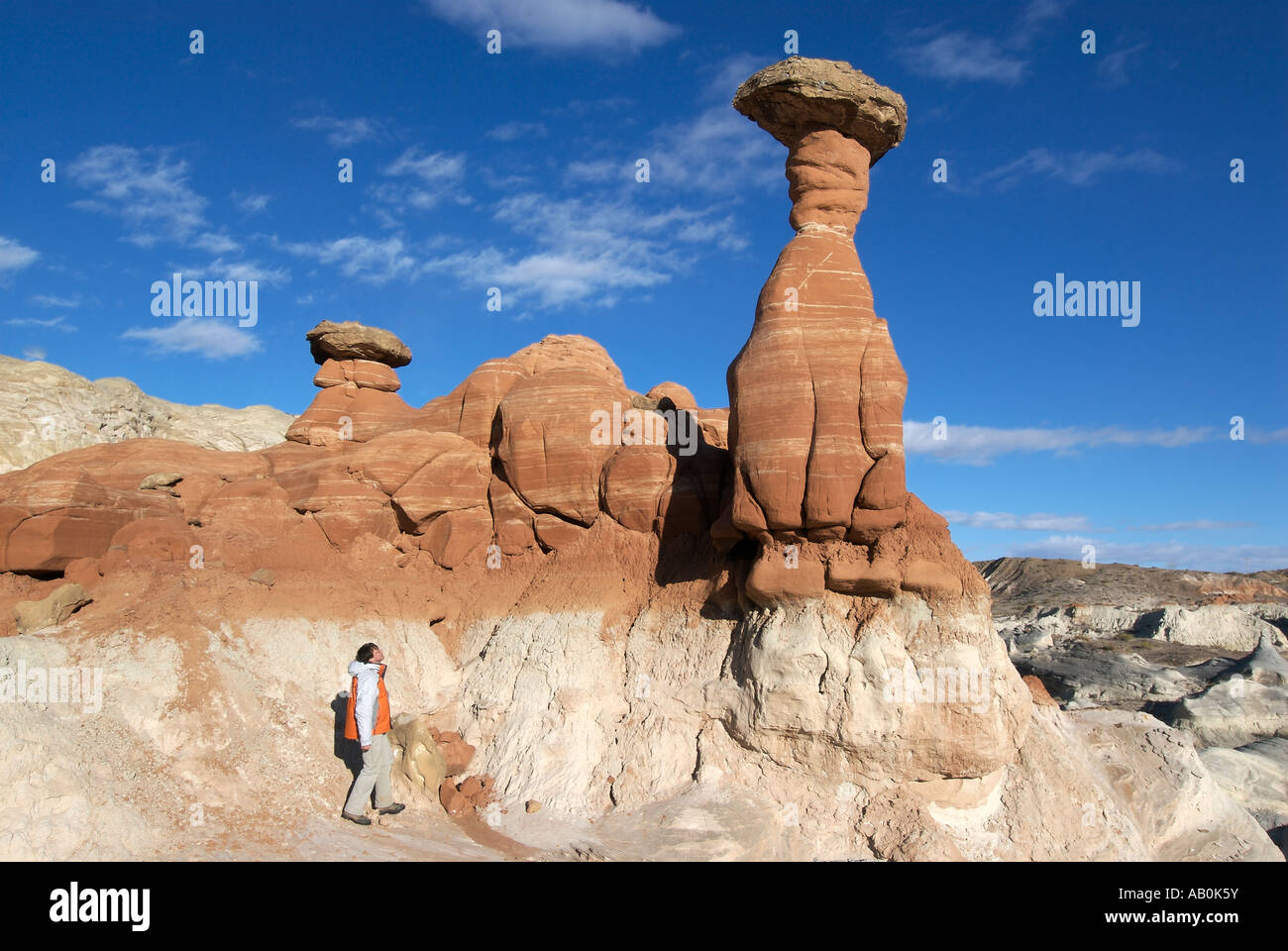 A hiker looks up at a collection of hoodoos in the Grand Staircase Escalante National Monument, Utah, Winter 2007 Stock Photo