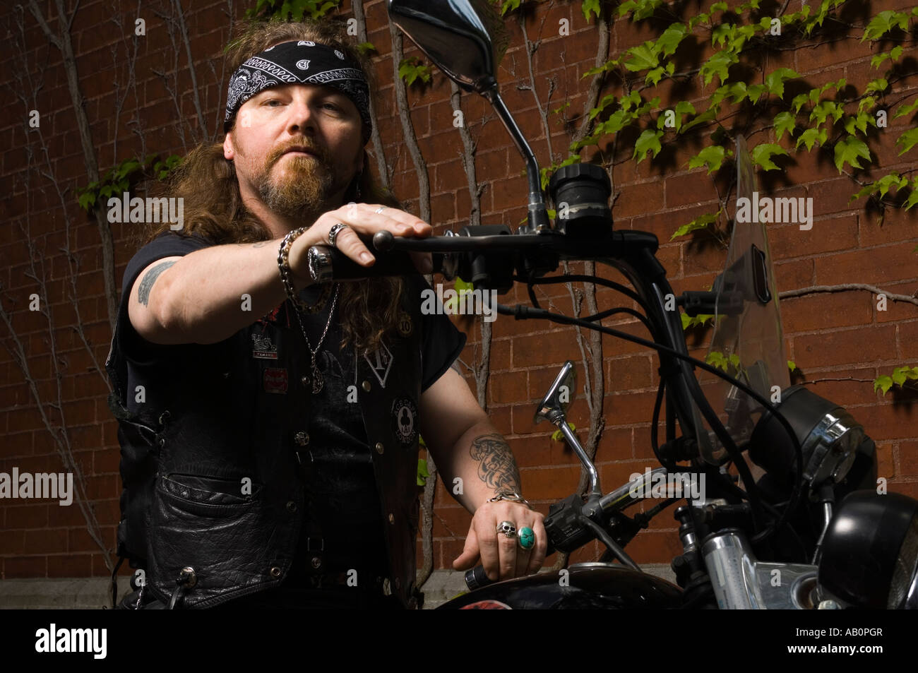 Biker behind bars with bandana Stock Photo - Alamy
