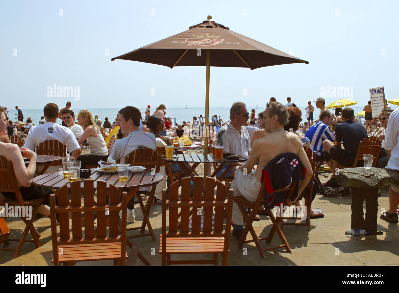Enjoying a drink in beachside bar on a busy hot summers day at Brighton UK Stock Photo