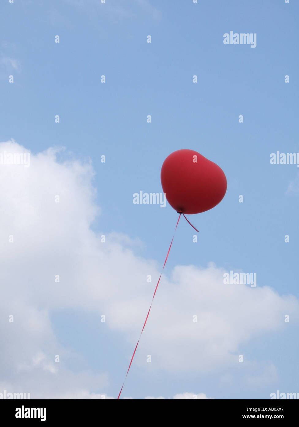 one heart shaped red balloon in blue sky Stock Photo - Alamy