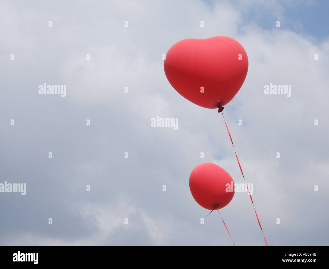 two heart shaped red balloons in blue sky Stock Photo - Alamy